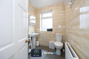 La salle de bains est pourvue de toilettes et d'un lavabo. dans l'établissement Luxurious & Spacious 2 Bedroom Home By Opuluxe Properties Short Lets & Serviced Accommodation Near Manchester City Center, à Manchester