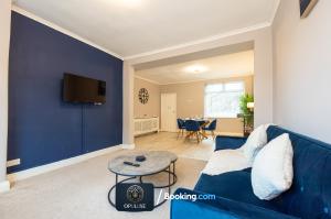 a living room with a blue couch and a table at Luxurious & Spacious 2 Bedroom Home By Opuluxe Properties Short Lets & Serviced Accommodation Near Manchester City Center in Manchester