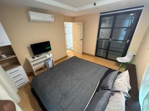 a bedroom with a bed and a flat screen tv at 2bd Apartment near icon Siam close to Everything in Bangkok