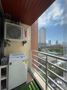 a balcony with a refrigerator and a view of a city at 2bd Apartment near icon Siam close to Everything in Bangkok