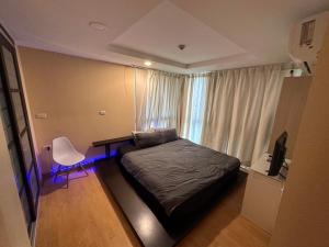a bedroom with a bed and a desk and a window at 2bd Apartment near icon Siam close to Everything in Bangkok
