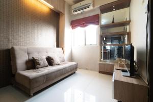 a living room with a couch and a television at THE SUITES METRO BY GOODVIBES APARTMENT in Bandung