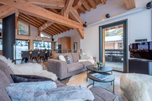 ein Wohnzimmer mit einem Sofa und einem Tisch in der Unterkunft Chalet Seven Summits - Pool - Sauna - Jacuzzi in Chamonix-Mont-Blanc