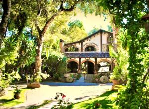 una casa grande con un patio con árboles en Hotel Hacienda Don Juan en San Cristóbal de Las Casas
