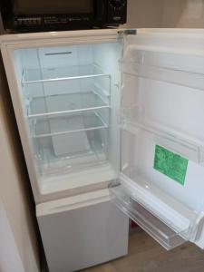 an empty refrigerator with its door open in a kitchen at 呉house in Ishigaki Island