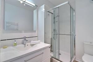a white bathroom with a sink and a shower at Central Park Elegant Studio balcony parking in Troyes