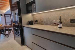 a kitchen with a counter with two glasses of wine at Ca la tita Casa rural**** in Salsadella