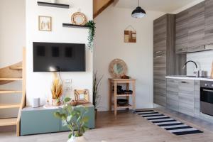 a kitchen with a flat screen tv on the wall at MIA ISOLA with lake view, garden and swimming pool in Parzanica