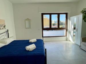 a bedroom with a blue bed with two towels on it at Poetto Beach House - Molara1 in Cagliari