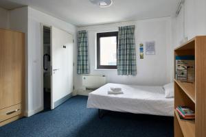 a small bedroom with a bed and a window at Ian Baker House in London