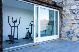 a room with a window and gym equipment at MIA ISOLA with lake view, garden and swimming pool in Parzanica