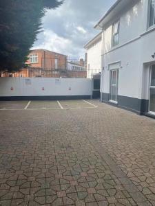 an empty parking lot next to a white building at Smart modern studio flat in central Bournemouth in Bournemouth