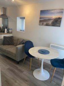 a living room with a couch and a table and chairs at Smart modern studio flat in central Bournemouth in Bournemouth