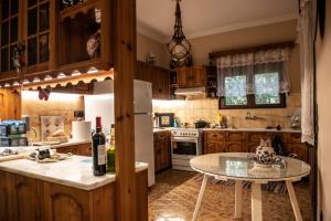 a kitchen with a table and a white refrigerator at Villa Olive and Sea in Mytilene