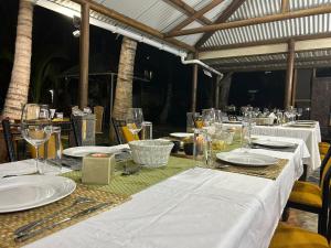 einen Tisch mit weißen Tellern und Weingläsern darauf in der Unterkunft Les Varangues Rodrigues in Rodrigues Island