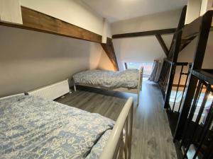 two beds in a small room with wooden floors at Luxe en ruim appartement in Rijksmonument in Vianen