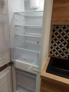un frigorifero vuoto con la porta aperta in una cucina di Cosy Haven 5 min from Nice Carnival Hyper-Center! a Nizza
