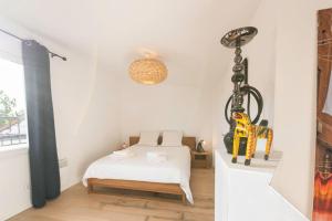 a bedroom with a white bed and a yellow chair at Joli Duplex Confort T2 Paris Porte De Versailles in Vanves