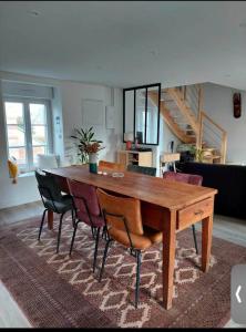 een houten tafel en stoelen in de woonkamer bij Duplex Cosy 100m2 Terrasse Fouesnant Les Glénan in Fouesnant