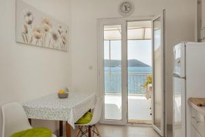 uma cozinha com uma mesa e vista para o oceano em Suberic Apartments em Herceg Novi