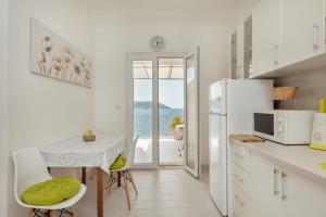 uma cozinha com uma mesa e um frigorífico branco em Suberic Apartments em Herceg Novi
