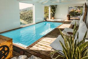 een zwembad met een houten terras en een groot raam bij Cerquido by NHôme in Cerquido