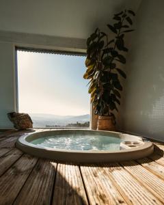 bañera de hidromasaje con ventana y suelo de madera en Cerquido by NHôme, en Cerquido