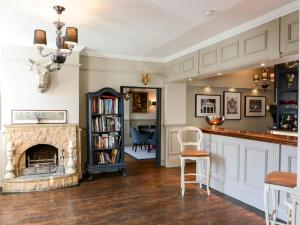 a living room with a fireplace and a bar at 5 Bed in Hurst Green 46916 in Robertsbridge
