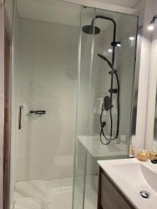 a shower with a glass door next to a sink at Termas Palguin Pucón in Pucón