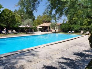 a swimming pool in front of a house at Logis Hotel le Mas De Cure Bourse in L'Isle-sur-la-Sorgue