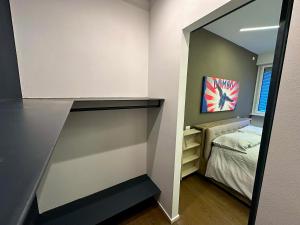 a small bedroom with a bed and a mirror at Casa Perini - Luxury Apartment in Trento