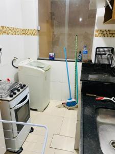 a kitchen with a stove and a sink and a counter at Aluga-se Apartamento todo no Parque Caravelas in Ipatinga