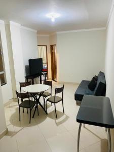 ein Wohnzimmer mit einem Tisch, Stühlen und einem Sofa in der Unterkunft Aluga-se Apartamento todo no Parque Caravelas in Ipatinga