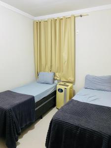 1 Schlafzimmer mit 2 Betten und einem Fenster in der Unterkunft Aluga-se Apartamento todo no Parque Caravelas in Ipatinga