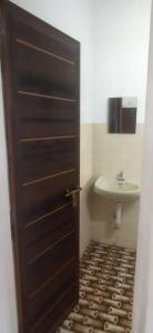 a bathroom with a sink and a brown door at Hornbill inn in Cochin