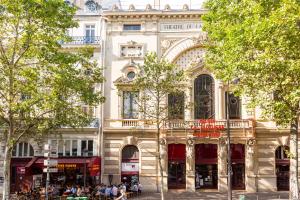 un gran edificio con gente sentada fuera de él en Veeve - Flowers in Saint-Martin en París