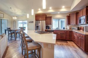 una cocina con armarios de madera y una isla de cocina con sillas en Welcoming Liberty Lake Home about 18 Mi to Spokane!, en Liberty Lake