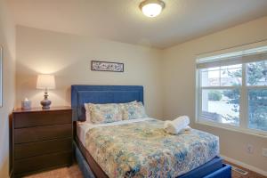 Un dormitorio con una cama azul y una ventana en Welcoming Liberty Lake Home about 18 Mi to Spokane!, en Liberty Lake