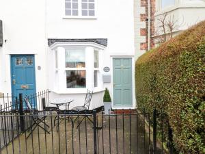 a white house with blue doors and a fence at Kestrel Cottage in Middlesbrough