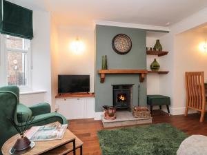 a living room with a fireplace and a tv at Kestrel Cottage in Middlesbrough