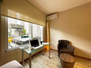 Zimmer mit einem Schreibtisch, einem Laptop und einem Stuhl in der Unterkunft RENTAPART BA in Buenos Aires