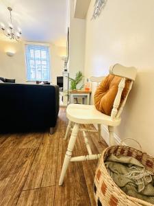 Sandlings في Filey: كرسي أبيض مع وسادة برتقال في غرفة المعيشة