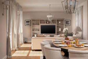 a living room with a table with chairs and a television at Luxury Villa Claretta near Porec for 8 people with sea view & pet friendly in Vabriga