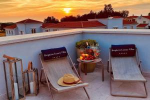 two chairs and a bowl of fruit on a balcony at Luxury Villa Claretta near Porec for 8 people with sea view & pet friendly in Vabriga