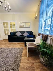 Sandlings في Filey: غرفة معيشة مع أريكة سوداء وكرسي
