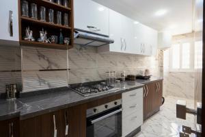a kitchen with white cabinets and a stove top oven at IMMOKA in Tangier