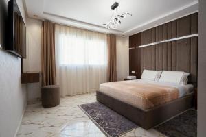 una camera d'albergo con letto e TV di Apart Hotel IMMOKA a Tangeri