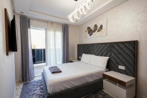 Un dormitorio con una cama grande y una ventana en Apart Hotel IMMOKA, en Tánger