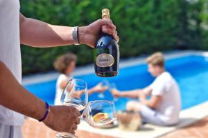 a man is holding a bottle of wine at Luxury Villa Constanza near Poreč for 8 people only 2 km from the sea in Vabriga