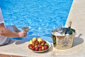 a person holding a glass of wine next to a bowl of fruit at Luxury Villa Constanza near Poreč for 8 people only 2 km from the sea in Vabriga